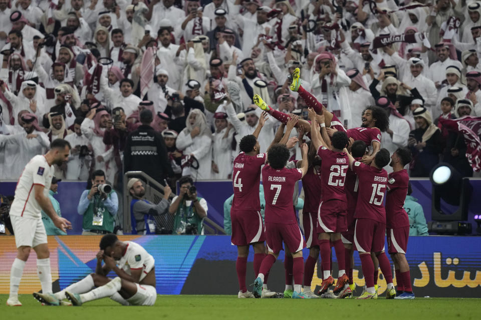 Qatar's players throw Akram Afif in the air as they celebrate Afif's three goals and their victory over Jordan in the Asian Cup final soccer match at the Lusail Stadium in Lusail, Qatar, Saturday, Feb. 10, 2024. (AP Photo/Thanassis Stavrakis)