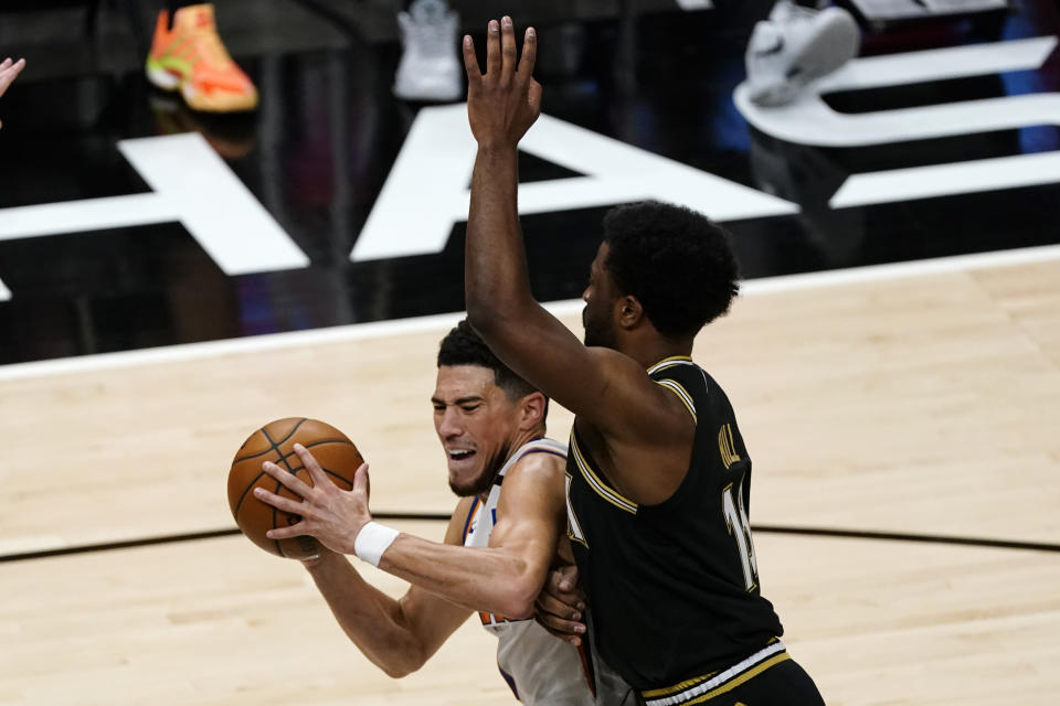 Phoenix Suns guard Devin Booker (1) drives against Atlanta Hawks forward Solomon Hill (18) in the first half of an NBA basketball game Wednesday, May 5, 2021, in Atlanta. (AP Photo/John Bazemore)