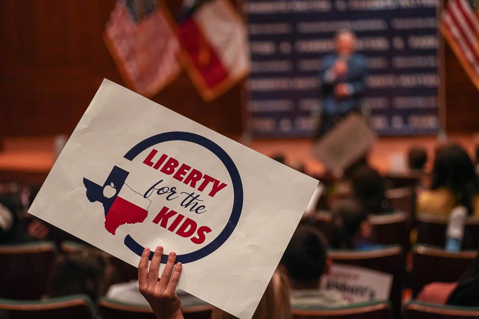 A child holds up a pro-school choice sign while listening to Gov. Greg Abbott speak Oct. 16 during a Parent Empowerment Rally in the Capitol.