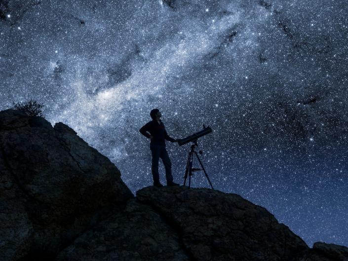Mężczyzna wpatrujący się w gwiazdy przez teleskop