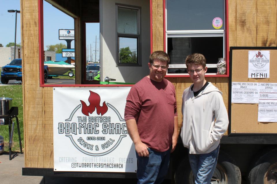 John O'brien, left, and Alexander Cova, right stand in front of the Two Brothers BBQ Mac Shack at Duey's on Grand River Avenue on May 24, 2022.
