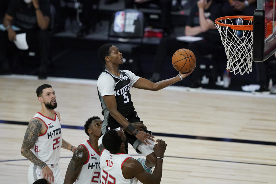 Sacramento Kings' De'Aaron Fox (5) shoots above Houston Rockets' Austin Rivers (25), Michael Frazier (21), and Jeff Green (32), during the second half of an NBA basketball game Sunday, Aug. 9, 2020, in Lake Buena Vista, Fla. (AP Photo/Ashley Landis, Pool)