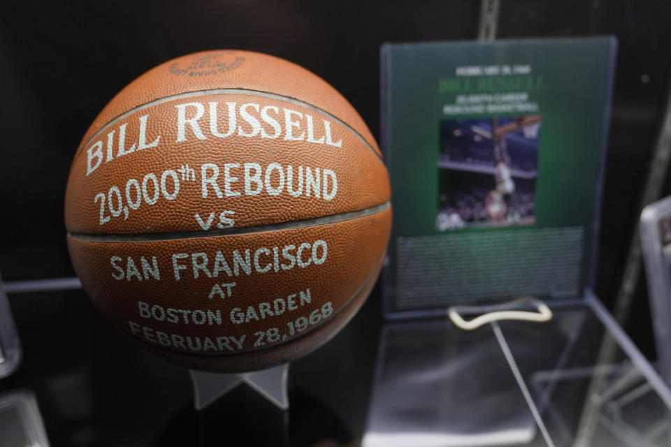 A basketball, honoring the 20,000th rebound by Boston Celtics' legend Bill Russell is displayed along with other memorabilia set to go up for auction, Thursday, Dec. 9, 2021, in Boston. Basketball fans hoping to buy something from Bill Russell's memorabilia collection should expect some big-name competition. Hall of Famers Shaquille O'Neal and Charles Barkley say they're interested in bidding on items that Russell is selling off. An online auction with 429 lots began last week and will culminate in a live event at the TD Garden on Friday, Dec. 10, 2021. (AP Photo/Charles Krupa)