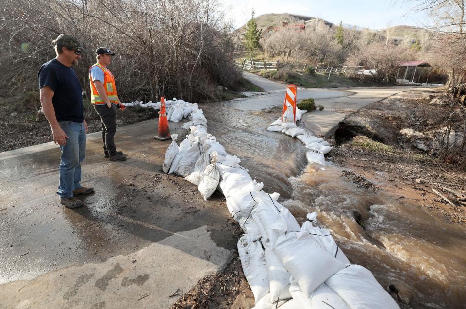 Landen Crump, Salt Lake County field supervisor, and Christian Olsen, Salt Lake County district worker, check on sandbags they previously set up at a road closure on Killyons Lane in Emigration Canyon on Tuesday, May 2, 2023. | Kristin Murphy, Deseret News