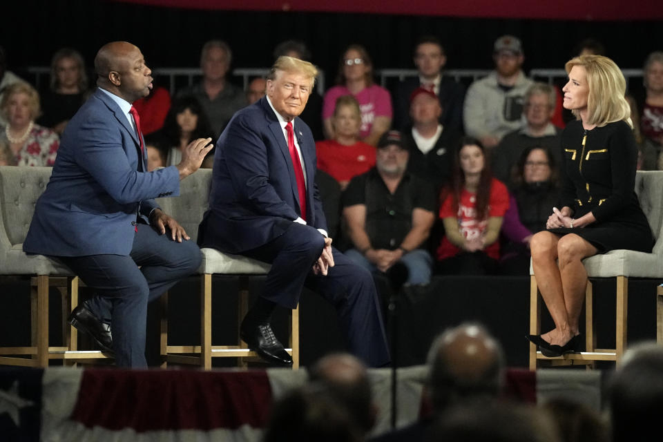 Republican presidential candidate former President Donald Trump listens as Sen. Tim Scott, R-S.C., talks to moderator Laura Ingraham during a Fox News Channel town hall Tuesday, Feb. 20, 2024, in Greenville, S.C. (AP Photo/Chris Carlson)