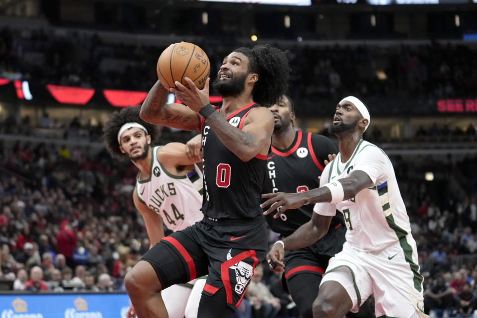 Chicago Bulls' Coby White drives to the basket between Milwaukee Bucks' Andre Jackson Jr. (44) and Bobby Portis during the first half of an NBA basketball game, Thursday, Nov. 30, 2023, in Chicago. (AP Photo/Charles Rex Arbogast)