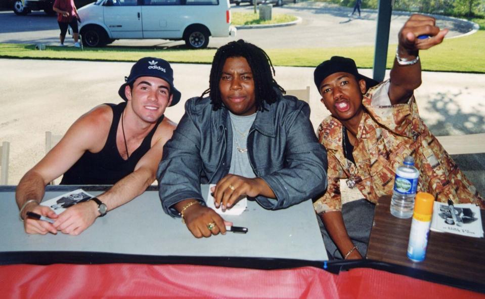 Three teenage boys hold sharpie pens waiting to sign autographs