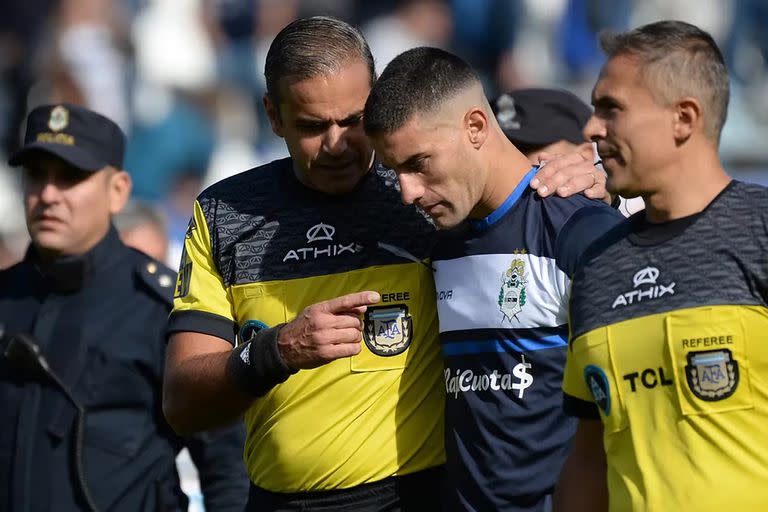 El árbitro Ariel Penel le da explicaciones a un futbolista de Gimnasia tras el gol anulado al Lobo en su partido contra Sarmiento