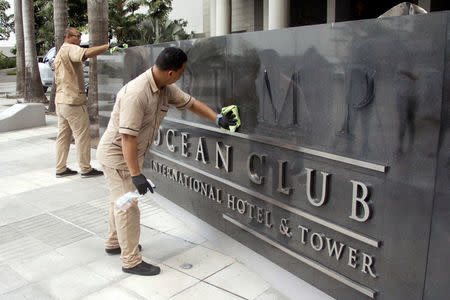 A worker cleans the site where the Trump name was removed from the Trump Ocean Club International Hotel and Tower in Panama City, Panama March 5, 2018. REUTERS/Carlos Lemos