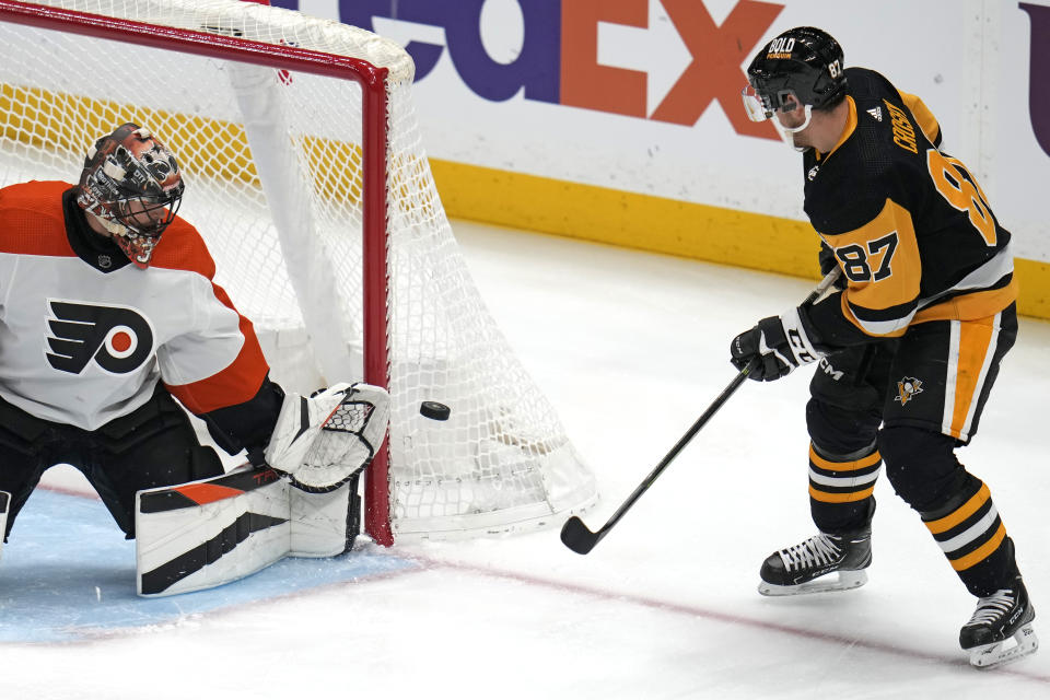 Pittsburgh Penguins' Sidney Crosby (87) cannot get a shot past Philadelphia Flyers goaltender Samuel Ersson, left, during the first period of an NHL hockey game in Pittsburgh, Saturday, Dec. 2, 2023. (AP Photo/Gene J. Puskar)