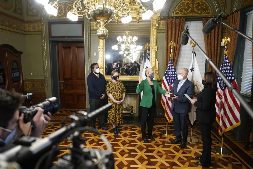 FILE - In this Feb. 25, 2021, file photo, Jennifer Granholm is sworn in as Energy Secretary by Vice President Kamala Harris, as her husband Dan Mulhern holds the Bible, in the Eisenhower Executive Office Building in the White House complex in Washington. Granholm's daughter Cecelia Mulhern and son-in-law Damian Roberto Mendieta, watch. The Biden administration is reviving an Energy Department program that dispersed billions of dollars in loan guarantees to companies such as electric car maker Tesla and the failed solar company Solyndra. In an interview with The Associated Press, Energy Secretary Jennifer Granholm says that up to $40 billion in guarantees will be made available for a variety of clean-energy projects. (AP Photo/Andrew Harnik, File)