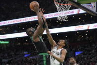 Boston Celtics guard Jaylen Brown, left, drives toward the basket as San Antonio Spurs guard Devin Vassell, right, defends in the first half of an NBA basketball game, Sunday, March 26, 2023, in Boston. (AP Photo/Steven Senne)