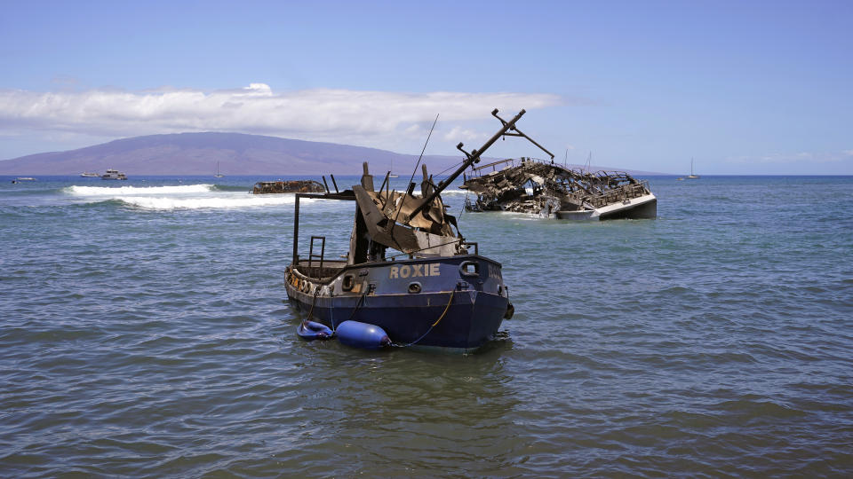 Burnt boats sit in waters off of Lahaina, Hawaii, on Friday, Aug. 11, 2023. The search of the wildfire wreckage on the Hawaiian island of Maui revealed a wasteland of burned out homes and obliterated communities. (AP Photo/Rick Bowmer)