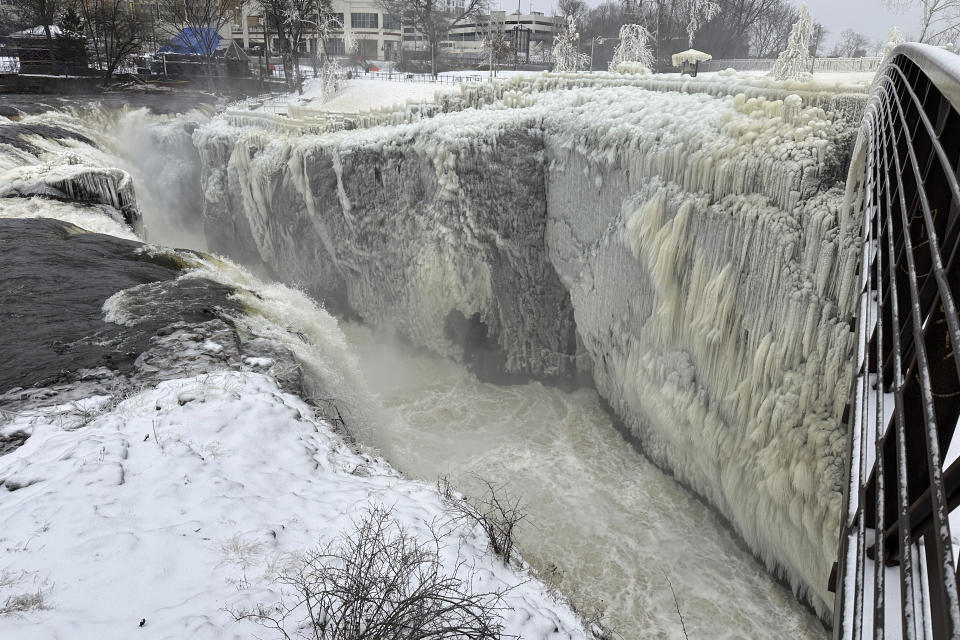 Mist from the Great Falls has created a frozen wonderland around the waterfalls in Paterson, N.J., on Thursday, Jan. 18, 2024. People are braving the subfreezing cold temps and slippery walkways to visit the ice-covered trees, benches and lamp posts. (AP Photo/Ted Shaffrey)