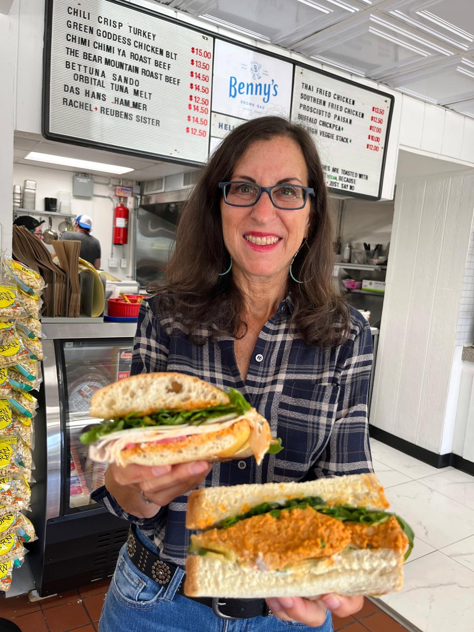 Lohud food and dining reporter Jeanne Muchnick with the Chili Crisp Turkey and Buffalo Chickpea sandwiches at Benny's Brown Bag in Peekskill, Sept. 1, 2023.