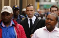 Olympic and Paralympic track star Oscar Pistorius arrives ahead of his trial for the murder of his girlfriend Reeva Steenkamp, at the North Gauteng High Court in Pretoria, March 13, 2014. Pistorius is on trial for murdering Steenkamp at his suburban Pretoria home on Valentine's Day last year. He says he mistook her for an intruder. REUTERS/Siphiwe Sibeko (SOUTH AFRICA - Tags: SPORT ATHLETICS CRIME LAW)