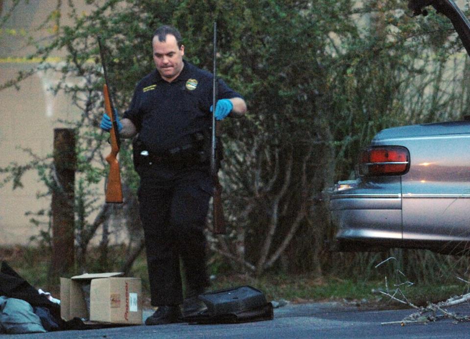 A Jacksonville Sheriff's Office crime scene technician removes guns from the trunk of a car on Manatok Street where a man was shot in this 2006 photo.