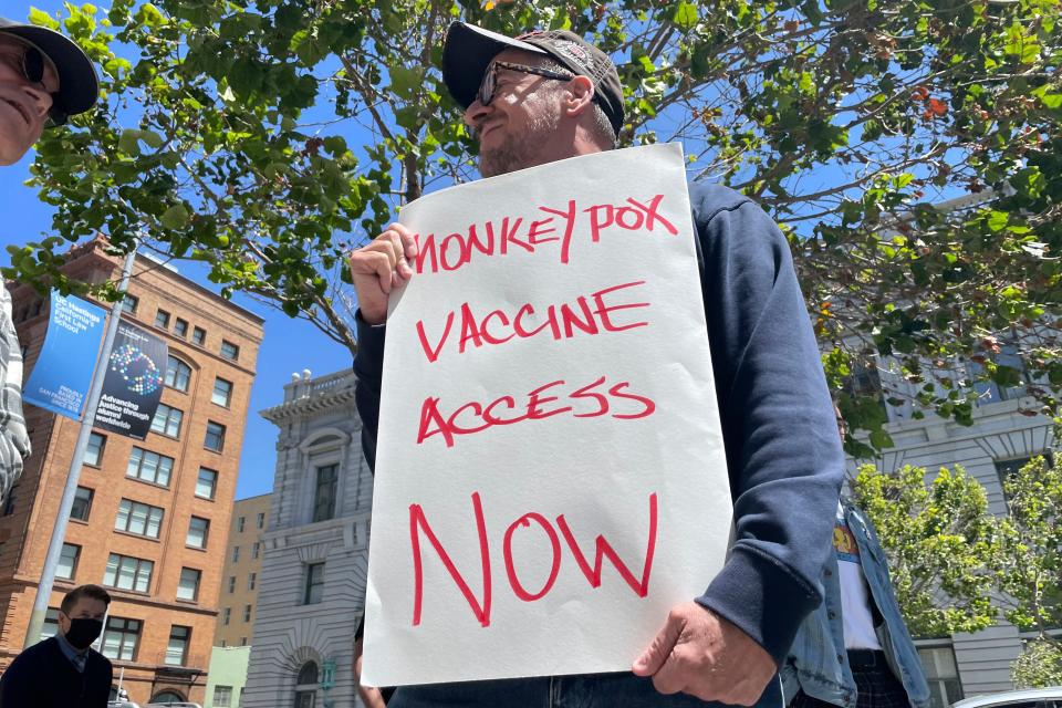 A man holds a sign urging increased access to the monkeypox vaccine during a protest in San Francisco on July 18, 2022. The mayor of San Francisco announced a legal state of emergency Thursday, July 28, 2022, over the growing number of monkeypox cases.