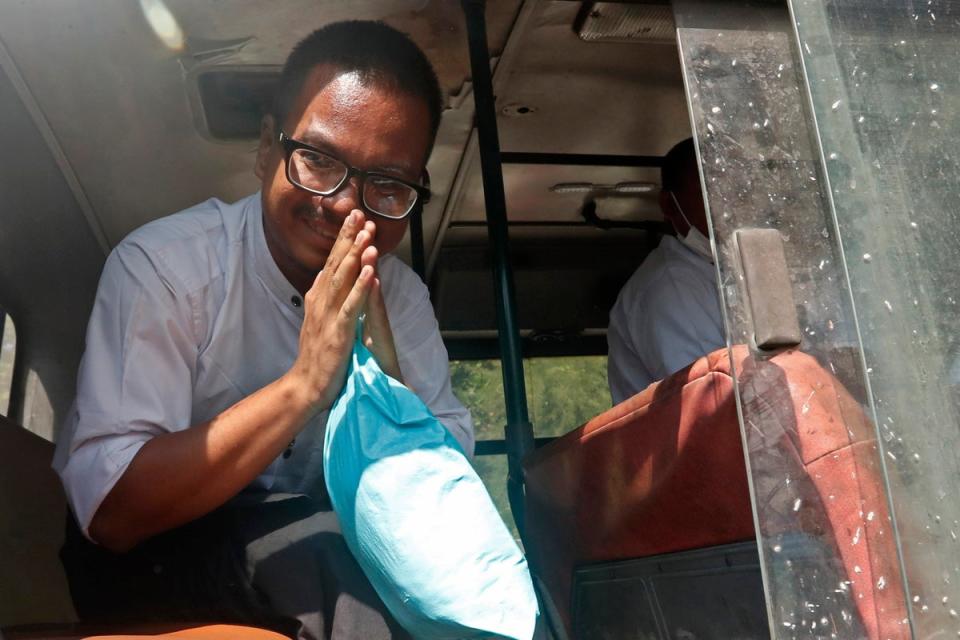 Freelance photographer Kaung Set Lynn greets attendees from inside a bus (EPA)