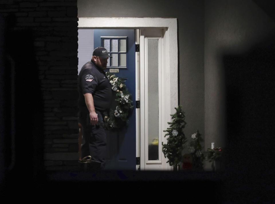 A law enforcement official stands at the front door of the Enoch, Utah, home where eight family members were found dead from gunshot wounds, Wednesday, Jan. 4, 2023. (Ben B. Brown/The Deseret News via AP)