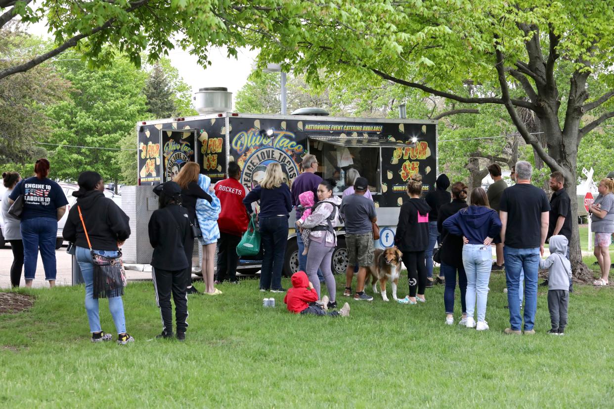 Customers gather around the Olivo Taco food truck on Tuesday, May 17, 2022, during Food Truck Tuesdays in Rockford.