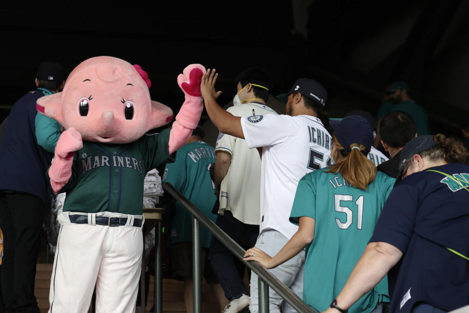 A mascot for Sato Pharmaceutical of Japan greets fans as they arrive on the day former Seattle Mariners player Ichiro Suzuki is inducted into the Mariners Hall of Fame in a pregame ceremony before a baseball game between the Mariners and the Cleveland Guardians, Saturday, Aug. 27, 2022, in Seattle. Ichiro, who prefers to use only his first name, joins nine other Mariners already in the Mariners HOF. Ichiro is a 10-time All-Star and American League Rookie of the Year in 2001. (AP Photo/John Froschauer)