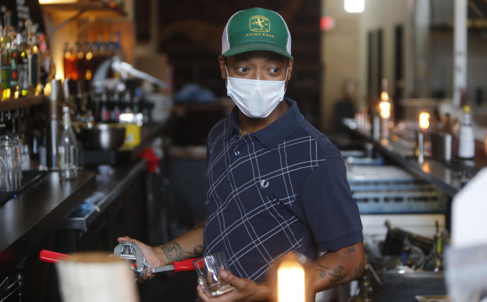 Omar Yeefoon, owner of Shoals Sound & Service vegan restaurant works behind the bar while the eatery is closed Tuesday, June 30, 2020, in Dallas. Yeefoon reopened his Dallas restaurant June 10 to "a pretty good reception," after having been shuttered for three months. The comeback was fleeting. After four days, Yeefoon had to shut down again in the face of a COVID-19 resurgence in Texas and lay off two of the four workers he'd brought back. (AP Photo/LM Otero)