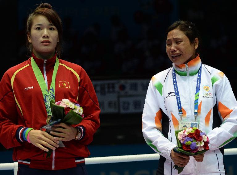 Sarita Devi (right) cries after she refused to accept a boxing bronze medal at the Asian Games in Incheon on October 1, 2014