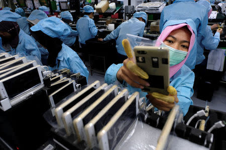 A worker holds an OPPO F1S smartphone at an OPPO smartphone factory in Tangerang, Indonesia, September 20, 2016. REUTERS/Beawiharta