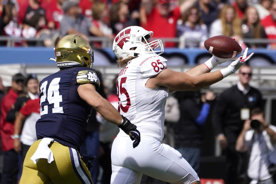 Wisconsin tight end Clay Cundiff (85) catches a pass as Notre Dame linebacker Jack Kiser defends during the first half of an NCAA college football game Saturday, Sept. 25, 2021, in Chicago. (AP Photo/Charles Rex Arbogast)