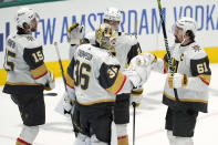 Vegas Golden Knights goaltender Logan Thompson (36) celebrates with Mark Stone (61), Noah Hanifin (15) and Zach Whitecloud (2) after Game 1 of an NHL hockey Stanley Cup first-round playoff series against the Dallas Stars in Dallas, Monday, April 22, 2024. The Golden Knights won 4-3. (AP Photo/Tony Gutierrez)