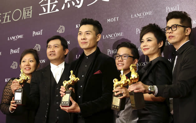 "Ilo Ilo" director Anthony Chen (third from left) poses with members of the film's cast and crew, and with their four Golden Horse awards. The film won for Best FIlm, Best Original Screenplay, Best New Director and Best Supporting Actress for Yeo Yann Yann. (Reuters photo)