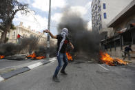 <p>Palestinians sling stonesin the West Bank city of Bethlehem during clashes with Israeli troops during a protest against the U.S. decision to relocate its embassy to Jerusalem, May 14, 2018. (Photo: Majdi Mohammed/AP) </p>