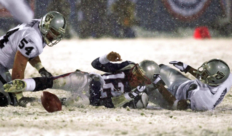 FILE - This photo by Associated Press photographer Elise Amendoal shows New England Patriots quarterback Tom Brady (12) losing the ball after being brought down by Oakland Raiders' Charles Woodson, right, while Raiders' Greg Biekert (54) moves to recover the ball, in the fourth quarter of their AFC Division Playoff game in Foxborough, Mass on Jan. 19, 2002. Amendola, who recently retired from the AP, died Thursday, May 11, 2023, at her home in North Andover, Mass., after a 13-year battle with ovarian cancer. She was 70. (AP Photo/Elise Amendola, File)