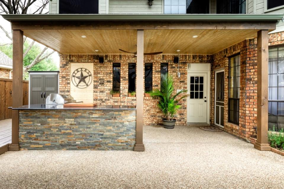 A modern outdoor kitchen with brickwork and wooden support posts