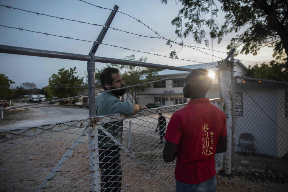 FILE - A manager at the Christian Aid Ministries headquarters, left, speaks with a worker at the door of the center in Titanyen, north of Port-au-Prince, Haiti, Sunday, Nov. 21, 2021. A year after 17 North American missionaries were kidnapped in Haiti, beginning a two-month ordeal before they ultimately went free, Christian Aid Ministries, the agency that sent them hasn't made a permanent return, and several other international groups have also scaled back their work there. (AP Photo/Odelyn Joseph)