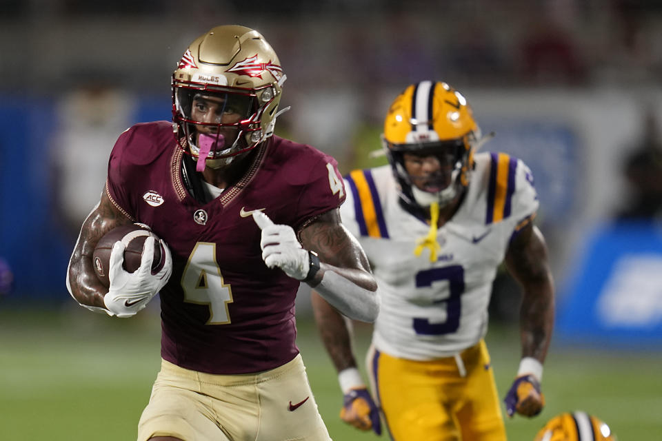 Florida State wide receiver Keon Coleman (4) runs past LSU safety Greg Brooks Jr. (3) for a 40-yard touchdown on a pass play during the first half of an NCAA college football game, Sunday, Sept. 3, 2023, in Orlando, Fla. (AP Photo/John Raoux)