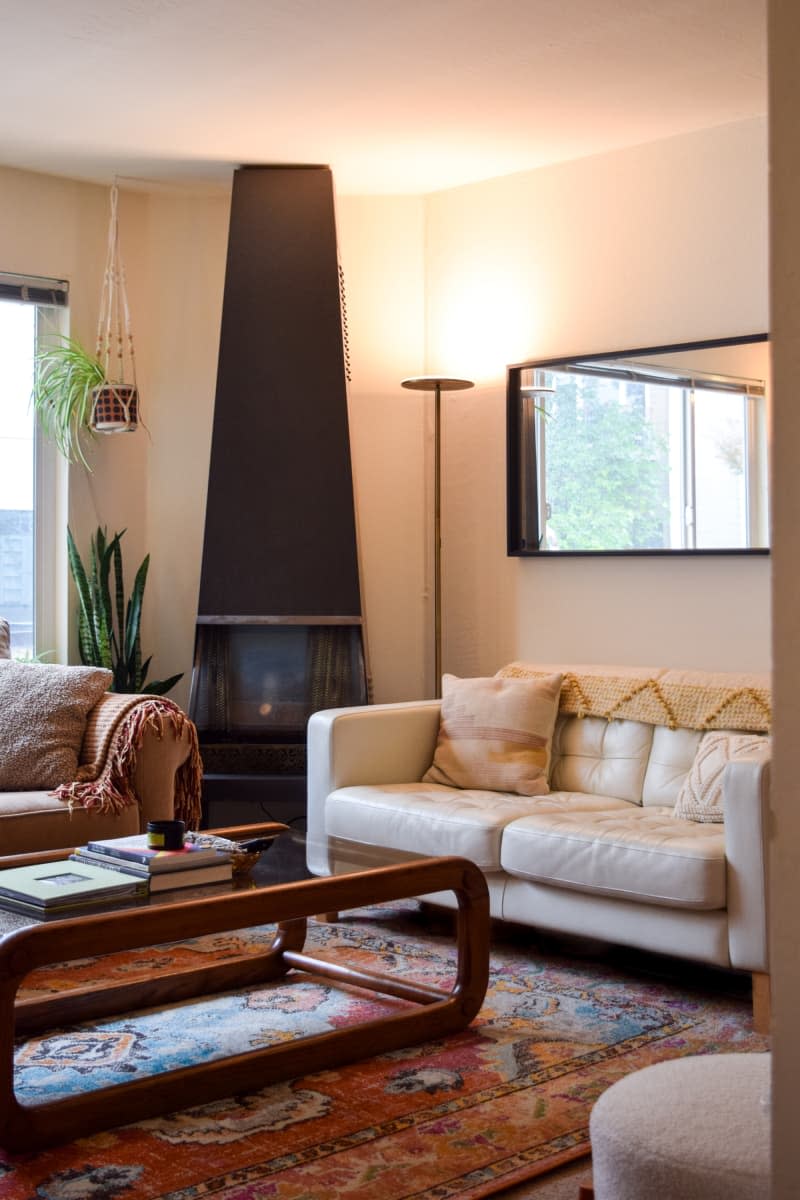 Black fireplace in the corner of the living room flanked by two couches