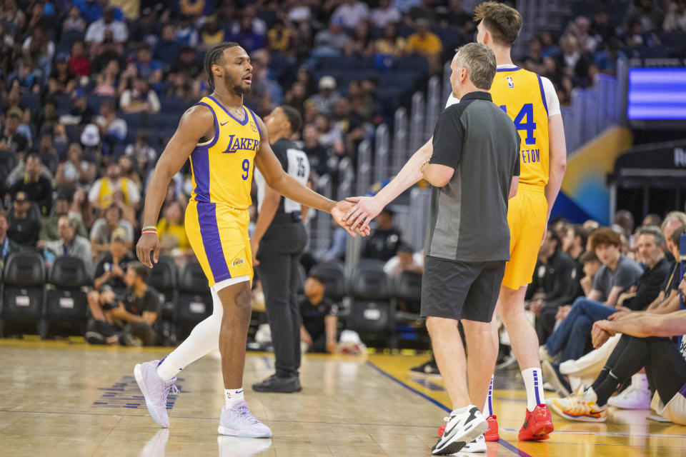 Los Angeles Lakers guard Bronny James (9) shakes hands with center Colin Castleton (14) during the first half of an NBA summer league basketball game against the Sacramento Kings in San Francisco, Saturday, July 6, 2024. (AP Photo/Nic Coury)