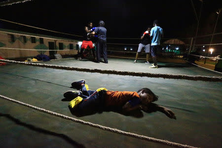 A boy sleeps inside the ring as Arafat Abkar (2nd R) , 22, practises boxing at Nile Club in Khartoum May 9, 2016. REUTERS/Mohamed Nureldin abdallah TPX IMAGES OF THE DAY