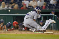 Washington Nationals' Dee Strange-Gordon slides past Colorado Rockies catcher Elias Diaz as he scores on a bunt single that was hit by Victor Robles in the eighth inning of a baseball game, Thursday, May 26, 2022, in Washington. Washington won 7-3. (AP Photo/Patrick Semansky)