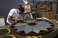 A carpenter works on restoring part of a door's windows glass that was shattered in a massive explosion last August in the Beirut port, at a workshop in Bsous village, Lebanon, Monday, June 28, 2021. The 60-year-old Sursock Museum is still rebuilding a year after the explosion. It was the beating heart of Beirut's arts community, and some hope that reopening it will be a first step in the harder task of rebuilding the city's once thriving arts scene. (AP Photo/Hussein Malla)