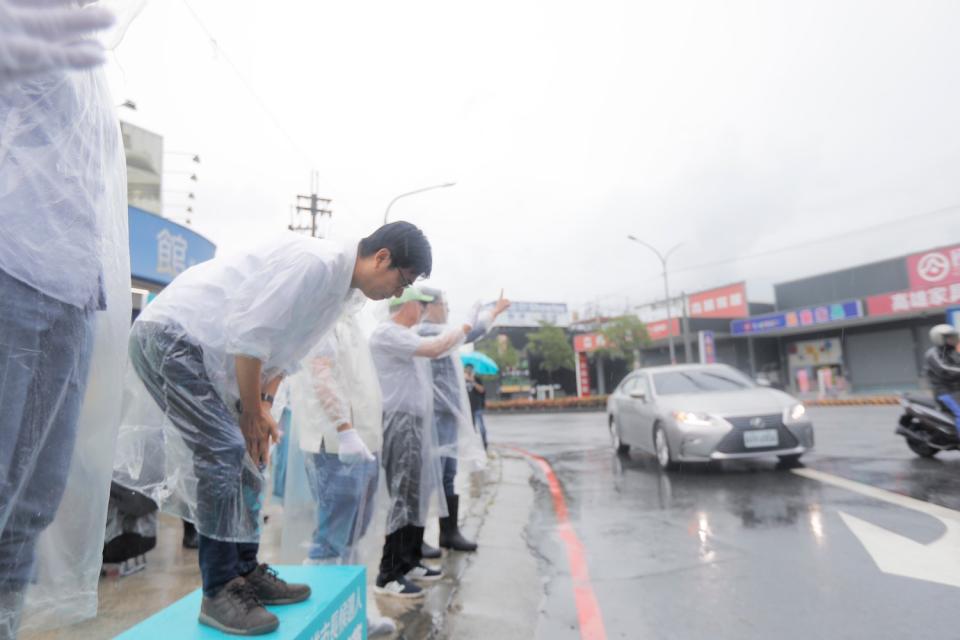 陳其邁(左)持續冒雨在路口向民眾拜票。   圖：陳其邁競辦/競辦