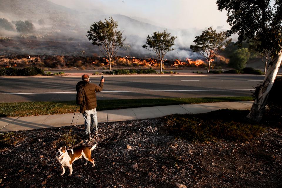 A resident watches from the side of the road the Easy Fire spreading in Simi Valley, North of Los Angeles, Calif., on Oct. 30, 2019. (Photo: Etienne Laurent/EPA-EFE/Shutterstock)