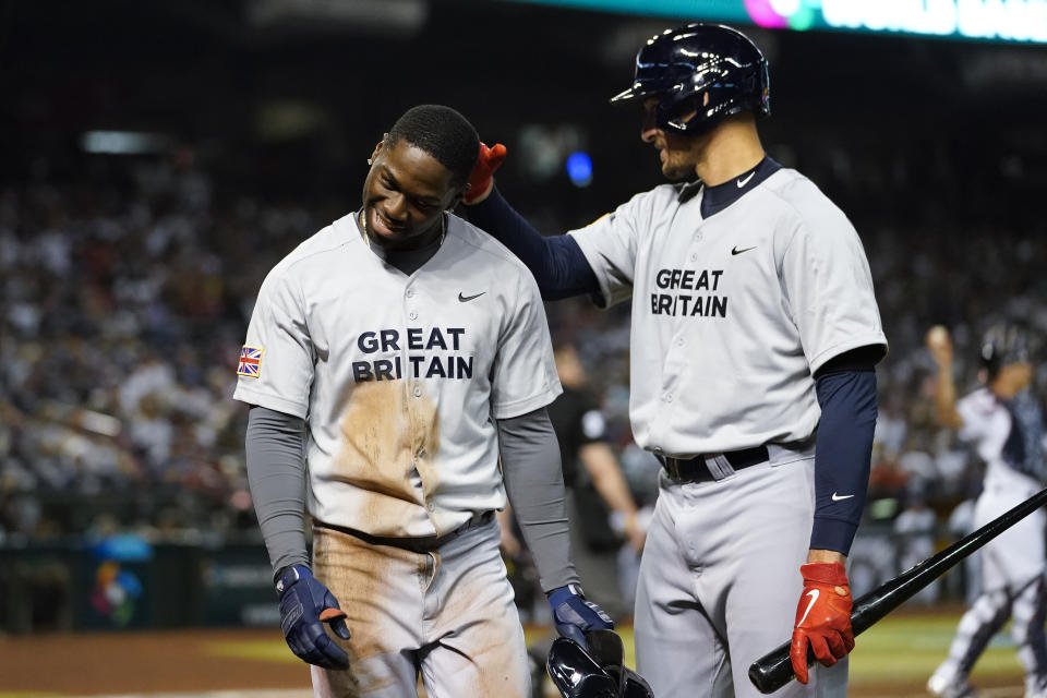 Great Britain's D'Shawn Knowles, left, celebrates with Trayce Thompson, right, after scoring against the United States on a groundout by Anfernee Seymour during the seventh inning of a World Baseball Classic game in Phoenix, Saturday, March 11, 2023. (AP Photo/Godofredo A. Vásquez)