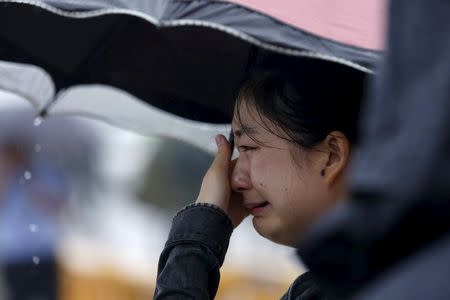 A relative of a missing passenger aboard a capsized ship cries on the banks of the Jianli section of Yangtze River in Hubei province, China, June 3, 2015. REUTERS/Aly Song