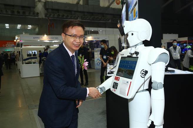 外貿協會10月底將舉辦兩大電子聯展，圖為2021年TAITRONICS當時參展商凌群電腦展示智慧機器人，貿協董事長黃志芳與其握手。(圖／貿協提供)