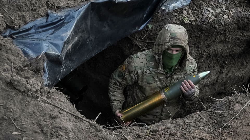 A Ukrainian serviceman holds an artillery shell near the town of Kreminna, Ukraine, March 4, 2024. - Inna Varenytsia/Reuters