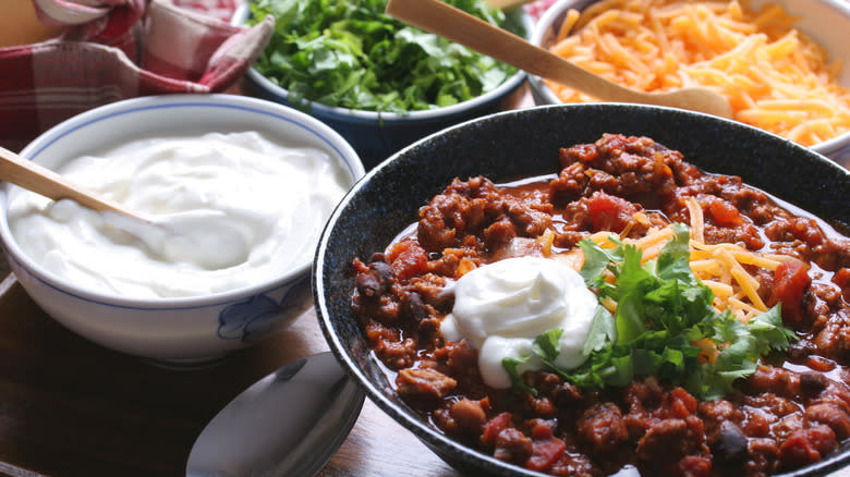 chili with cheese, sour cream, and cilantro