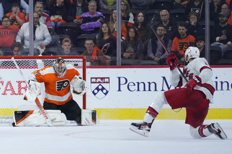 Carolina Hurricanes' Brent Burns, right, scores the game-winning goal against Philadelphia Flyers' Carter Hart during overtime in an NHL hockey game, Saturday, Oct. 29, 2022, in Philadelphia. (AP Photo/Matt Slocum)